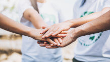 A team of people putting their hands together