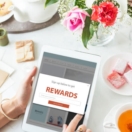 A person holding a tablet with rewards window
